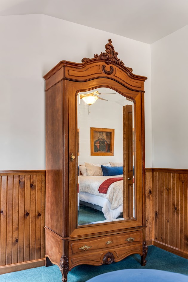 An antique mirrored armoire in a guest room at The Wildflower Hotel